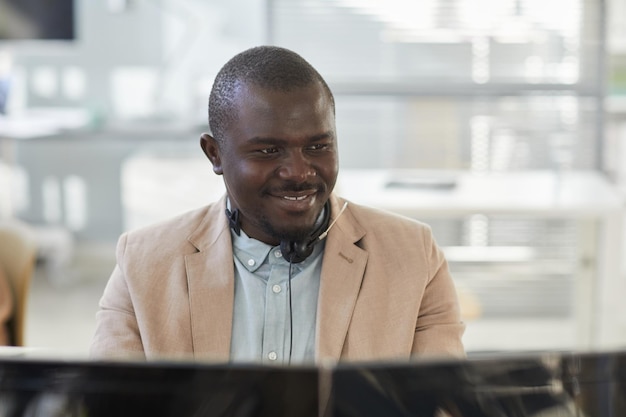Uomo di colore sorridente guardando lo schermo del computer