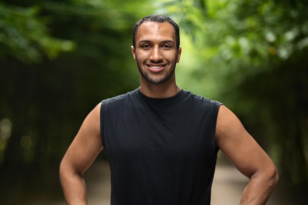 Uomo di colore sportivo bello che pareggia nel parco pubblico