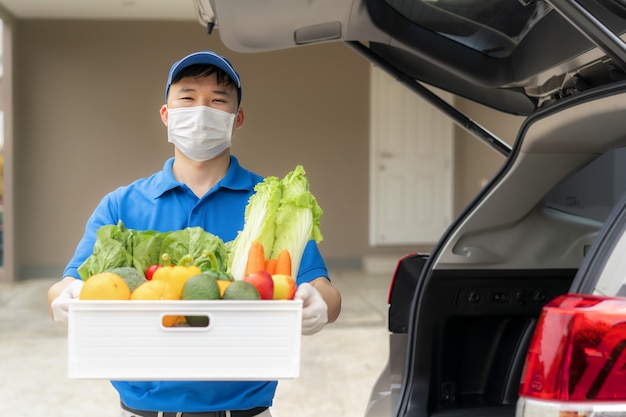 Uomo di consegna asiatico con scatola di generi alimentari di cibo