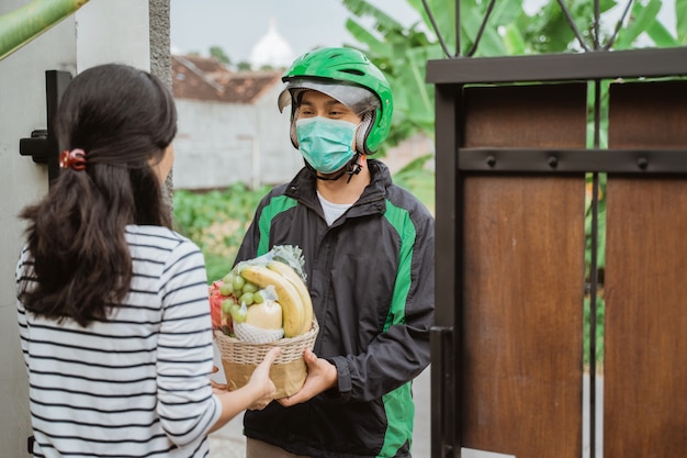 Uomo di consegna indossare maschera durante la consegna di cibo