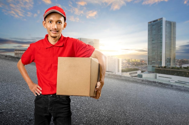 Uomo di consegna pacchi con un cappello che trasporta un pacco