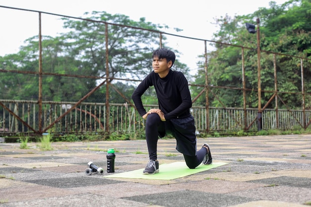 Uomo di forma fisica che allunga le gambe prima di fare allenamento all'aperto