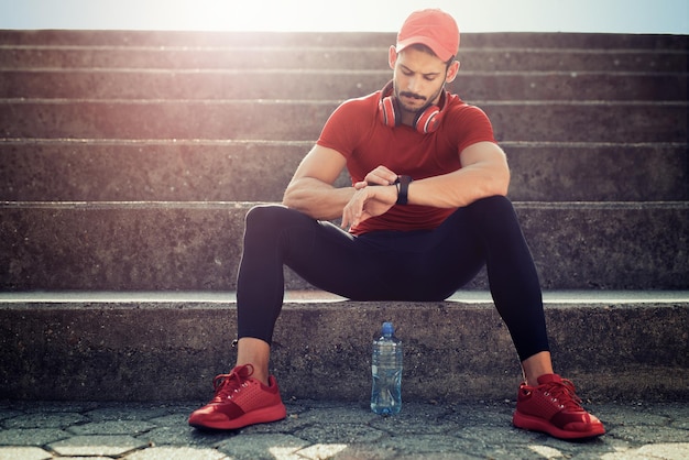 Uomo di forma fisica che controlla le prestazioni dopo l'allenamento