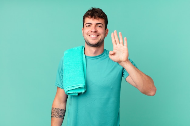 Uomo di forma fisica che sorride e sembra amichevole, mostrando il numero quattro o il quarto con la mano in avanti, conto alla rovescia