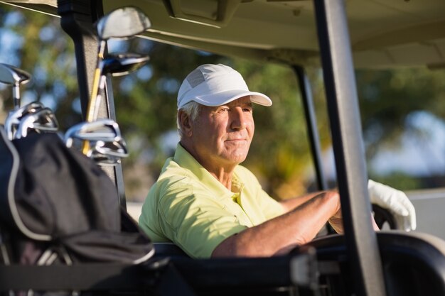 Uomo di golfista riflessivo guardando lontano