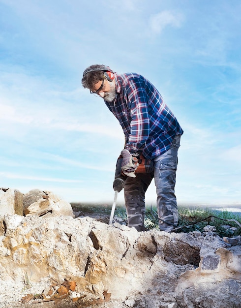 Uomo di lavoro con martello pneumatico su un muro