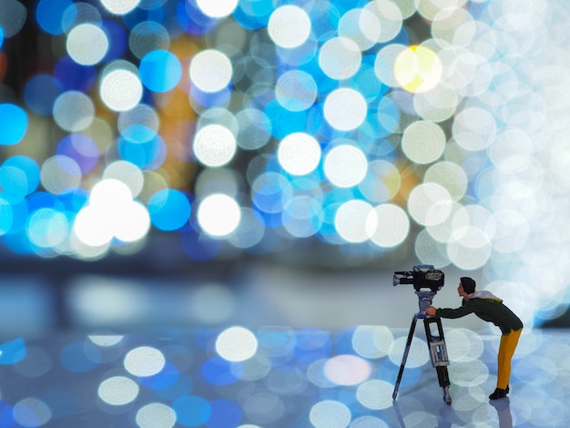 Uomo di macchina fotografica in miniatura con una bella luce bokeh sfondo. Natale e felice anno nuovo concetto.