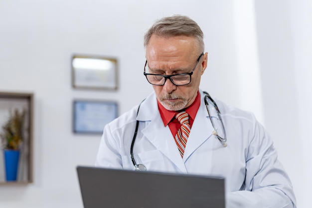 Uomo di medicina bello alla moda in vetri Operatore medico attraente che lavora con il computer portatile in vetri