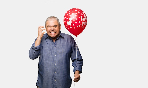 Uomo di mezza età che celebra il giorno di San Valentino arrabbiato e sconvolto