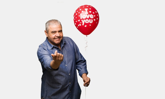 Uomo di mezza età che celebra il giorno di San Valentino che invita a venire