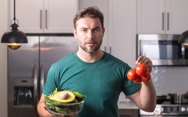 Uomo di mezza età che cucina in cucina uomo in cucina con verdure ritratto di uomo casual che cucina in