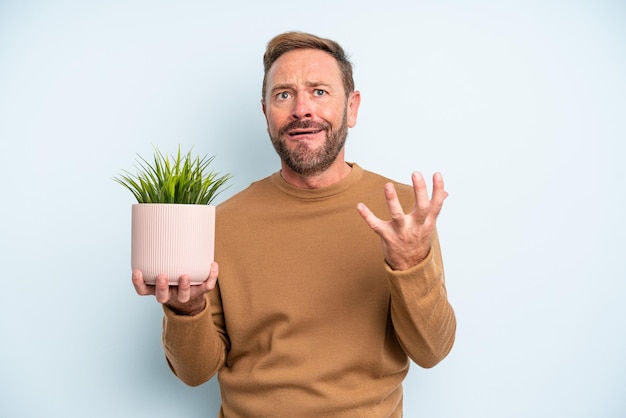 Uomo di mezza età che sembra disperato, frustrato e stressato. concetto di vaso per piante