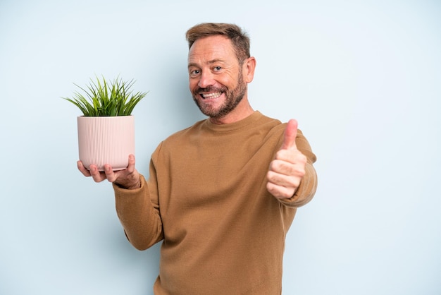 Uomo di mezza età che si sente orgoglioso, sorride positivamente con i pollici in su. concetto di vaso per piante