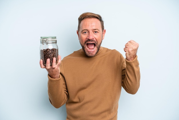 Uomo di mezza età che si sente scioccato, ride e celebra il successo. concetto di chicchi di caffè