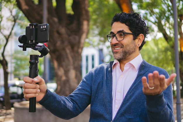 Uomo di mezza età che spiega qualcosa attraverso un video che sta registrando con un gimbal