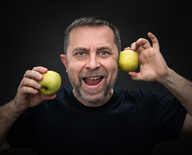 Uomo di mezza età con mele verdi