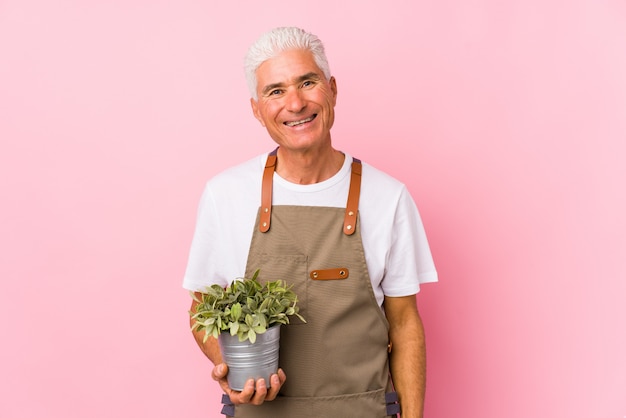 Uomo di mezza età giardiniere felice, sorridente e allegro