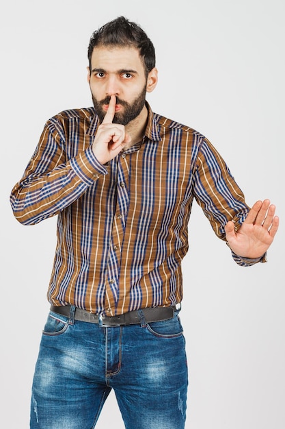 Uomo di mezza età in jeans sbiaditi e camicia su sfondo bianco che mostra diverse emozioni