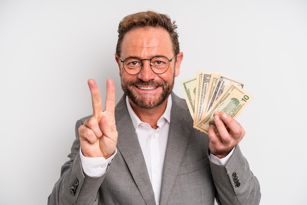 Uomo di mezza età sorridente e dall'aspetto amichevole che mostra il concetto di banconote in dollari numero due