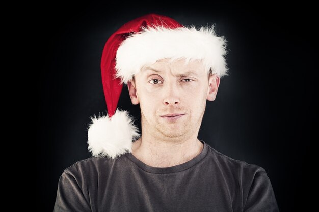 Uomo di Natale sorridente con cappello da Babbo Natale su sfondo scuro