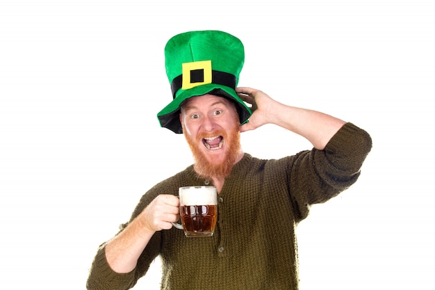 Uomo di redhead con un grande cappello verde che beve una birra