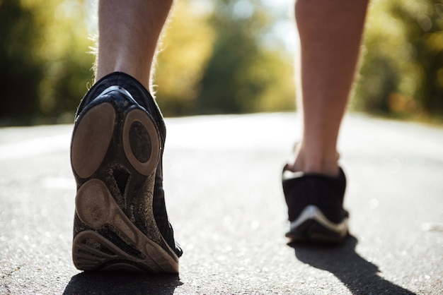 Uomo di retrovisione che corre nel parco. immagine ravvicinata. ritagliata