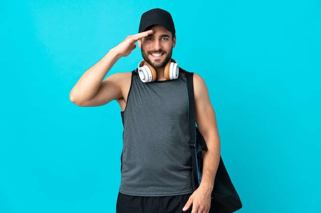 uomo di sport con borsa sportiva che saluta con la mano con felice espressione