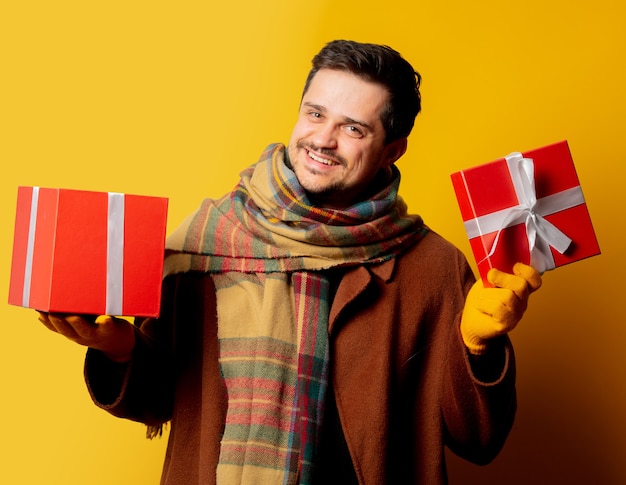 Uomo di stile in cappotto e sciarpa con confezione regalo