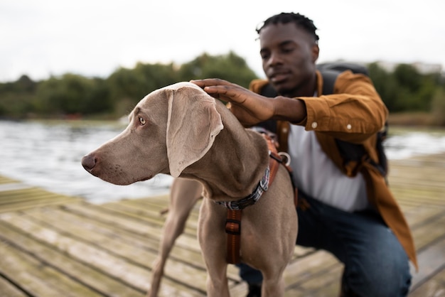 Uomo di tiro medio che accarezza il cane all'aperto