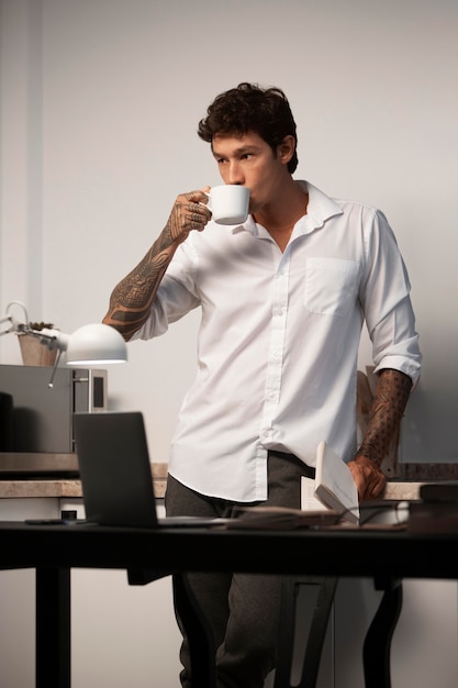 Uomo di tiro medio che beve caffè