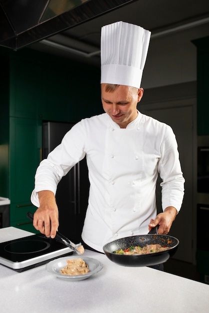 Uomo di tiro medio che cucina con la padella