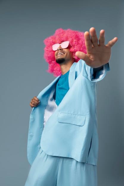 Uomo di tiro medio con parrucca rosa e occhiali
