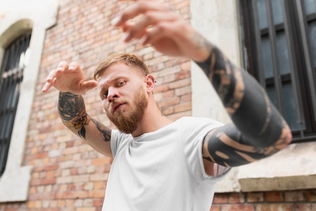 Uomo di tiro medio con tatuaggi in posa