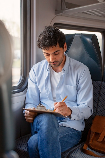 Uomo di vista frontale che viaggia in treno