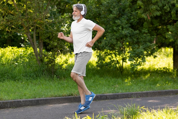 Uomo di vista laterale che corre all'aperto