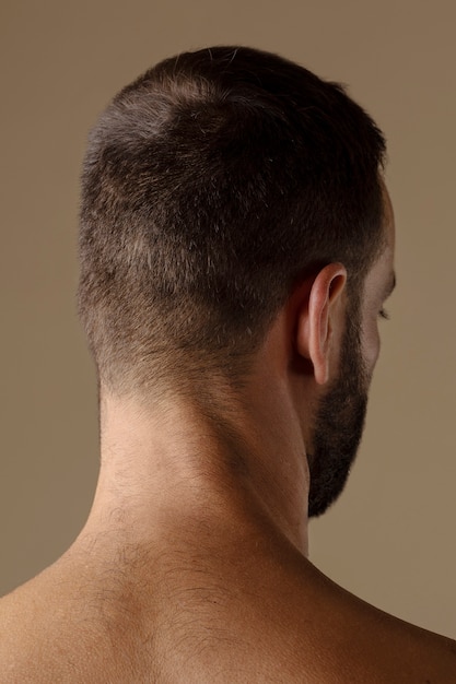 Uomo di vista posteriore con la posa della barba