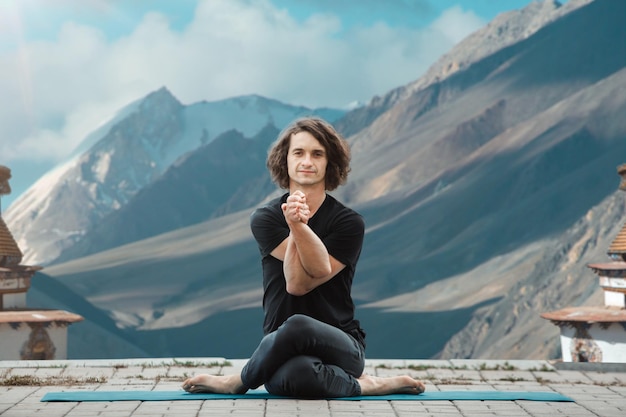 Uomo di yoga Giovane che fa yoga in loft all'alba