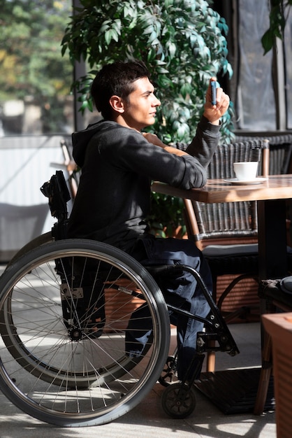 Uomo disabile del colpo pieno che prende le foto