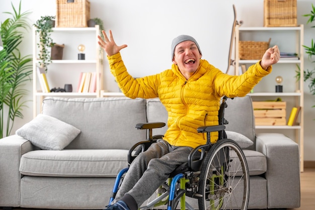 Uomo disabile felice ed espressivo in sedia a rotelle a casa