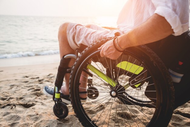 Uomo disabile in sedia a rotelle sulla spiaggia.