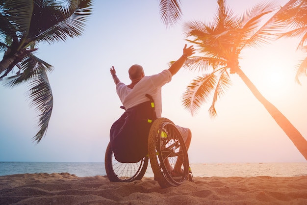 Uomo disabile in sedia a rotelle sulla spiaggia.