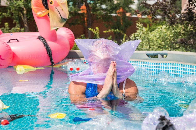 uomo disperato e speranzoso con un sacchetto di plastica sopra la testa in una piscina sporca.