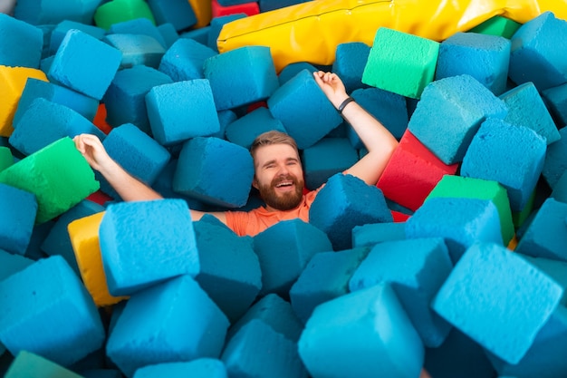 Uomo divertente e felice che si diverte su un trampolino al chiuso