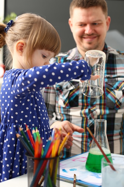 Uomo e bambina giocano con liquidi colorati