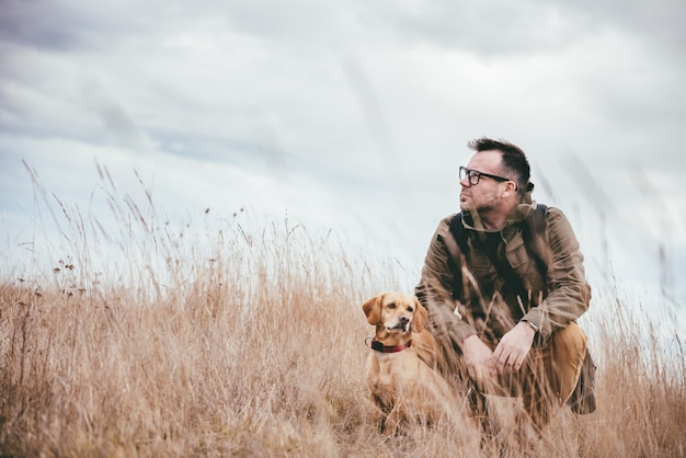 Uomo e cane in erba alta