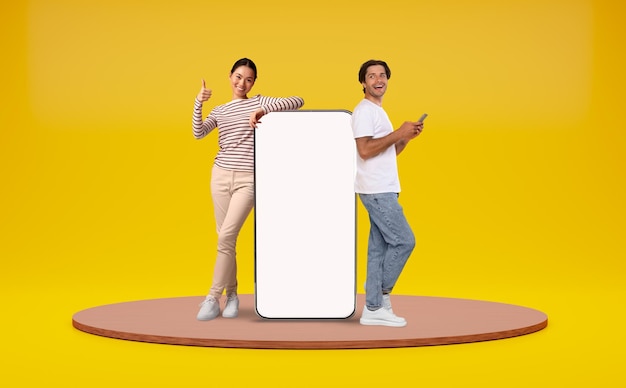 Uomo e donna appoggiati a un grande smartphone con uno schermo bianco vuoto