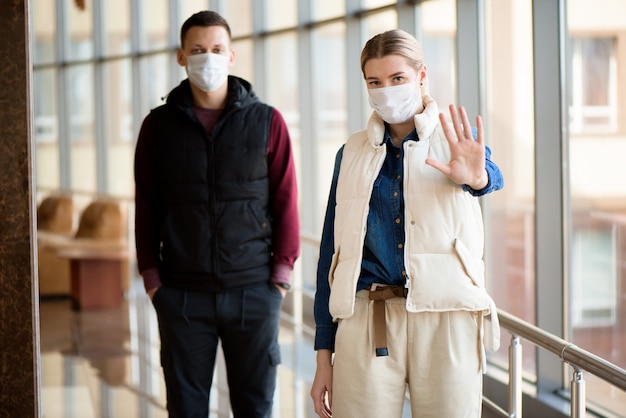 uomo e donna che camminano con maschere mediche