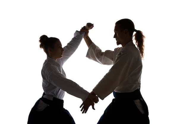 Uomo e donna che combattono durante l'allenamento di Aikido nella scuola di arti marziali