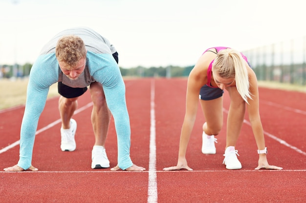 uomo e donna che corrono su pista all'aperto