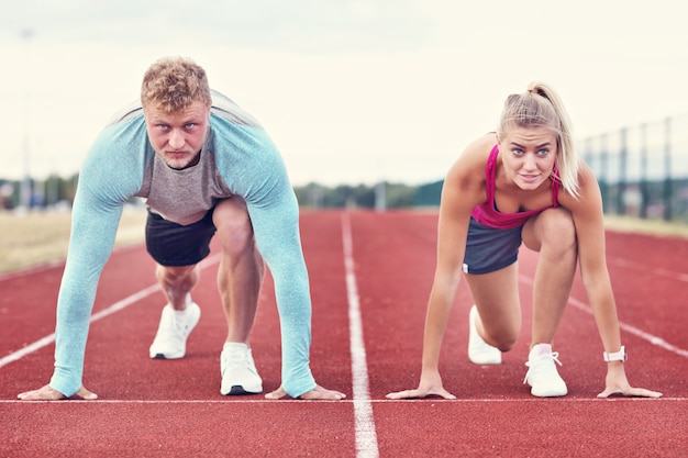 uomo e donna che corrono su pista all'aperto